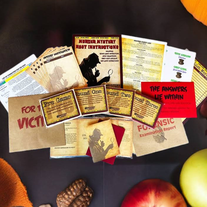 An autumn-themed flat lay featuring a collection of mystery rogues and crime-themed cards, pamphlets, and small tickets arranged in the center. The scene is styled with seasonal props including orange pumpkins, red and green apples, brown leaves, and a small pinecone on a dark background.