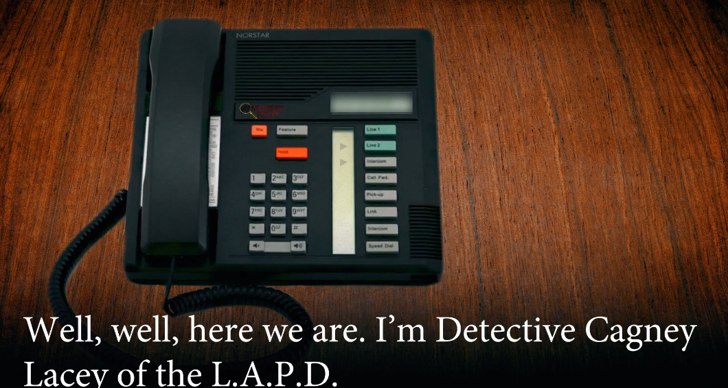 A black landline telephone with a coiled cord sits on a dark brown wooden surface. White text at the bottom reads, 'Well, well, here we are.