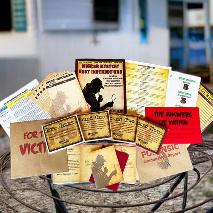 A set of printed cards and small signs displayed on a metal table outdoors, with an RV and pink flamingos blurred in the background. Visible text includes 'HARDWORK AFTERY ROOT INTERNATIONAL,' 'FOR VICTIM,' 'THE ANSWERS ARE WITHIN,' and 'FOCUS INSPIRATION.