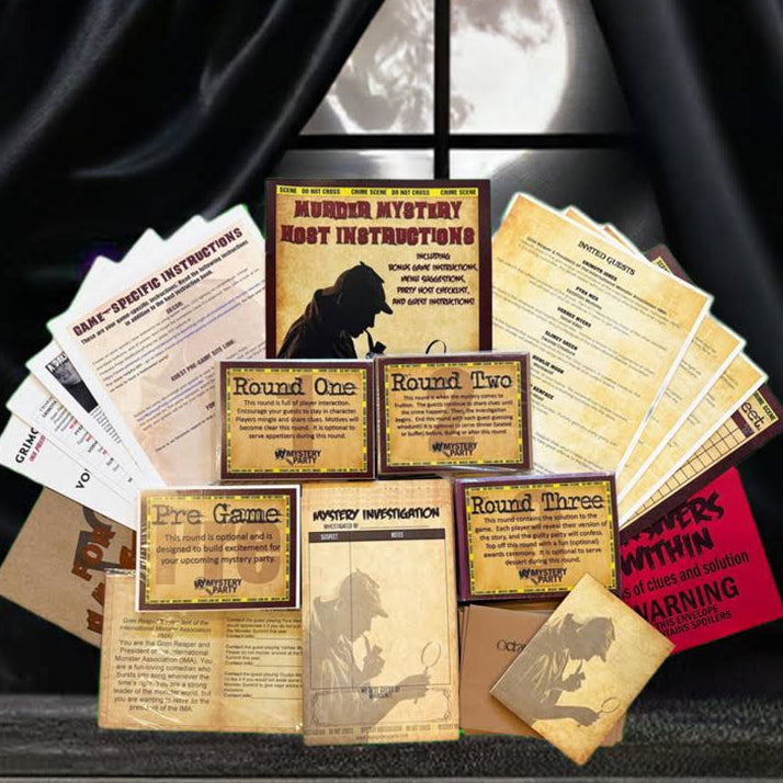 A collection of vintage-style mystery game cards and booklet covers arranged on a dark surface in front of black draped curtains with a full moon visible behind them. The set includes tan, cream, and red printed cards and boxes with illustrated wolf and ghost motifs.
