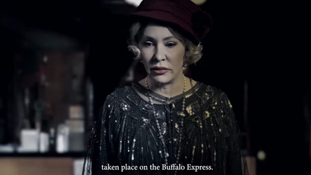 A woman wearing a dark beaded fringe top, a dark red hat, and pearl earrings, shown in a dimly lit setting with English subtitles at the bottom.