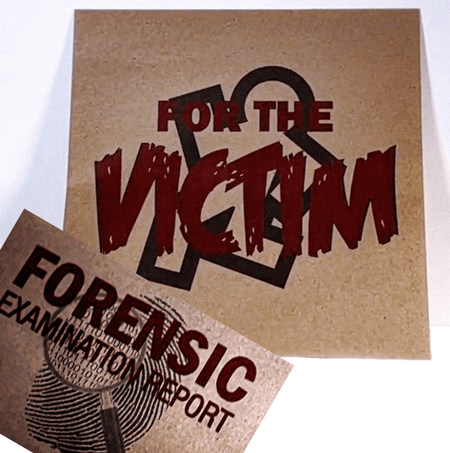 A square kraft-paper style print or card with the words 'FOR THE VICTIM' in large distressed red lettering over a black ampersand graphic, with a second matching print partially visible in front reading 'FORENSIC EXAMINATION REPORT.'.