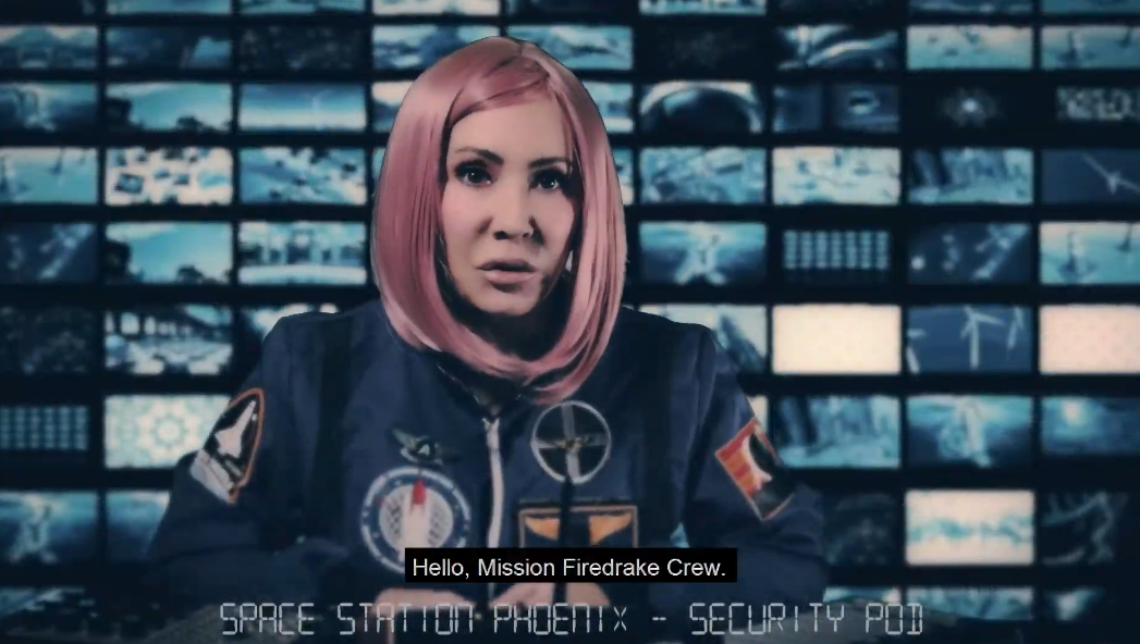 A woman with pink hair wearing a dark blue astronaut flight suit sits in front of a wall of blue-toned monitors, with text at the bottom reading 'Hello, Mission Firedrake Crew.' and 'SPACE STATION PHOENIX - SECURITY POI'.