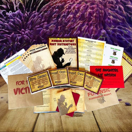 A collection of printed evidence-examination cards, worksheets, and small cards arranged on a wooden tabletop, with a dramatic fireworks display in the background. Visible text includes 'HARDLY ATTYWE ART DEPARTMENT' and 'THE ANSWERS LIE WITHIN'.